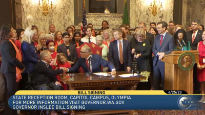 Jay Inslee shakes the hand of a participant at the signing of HB 1240 to ban assault weapon sales in Washington
